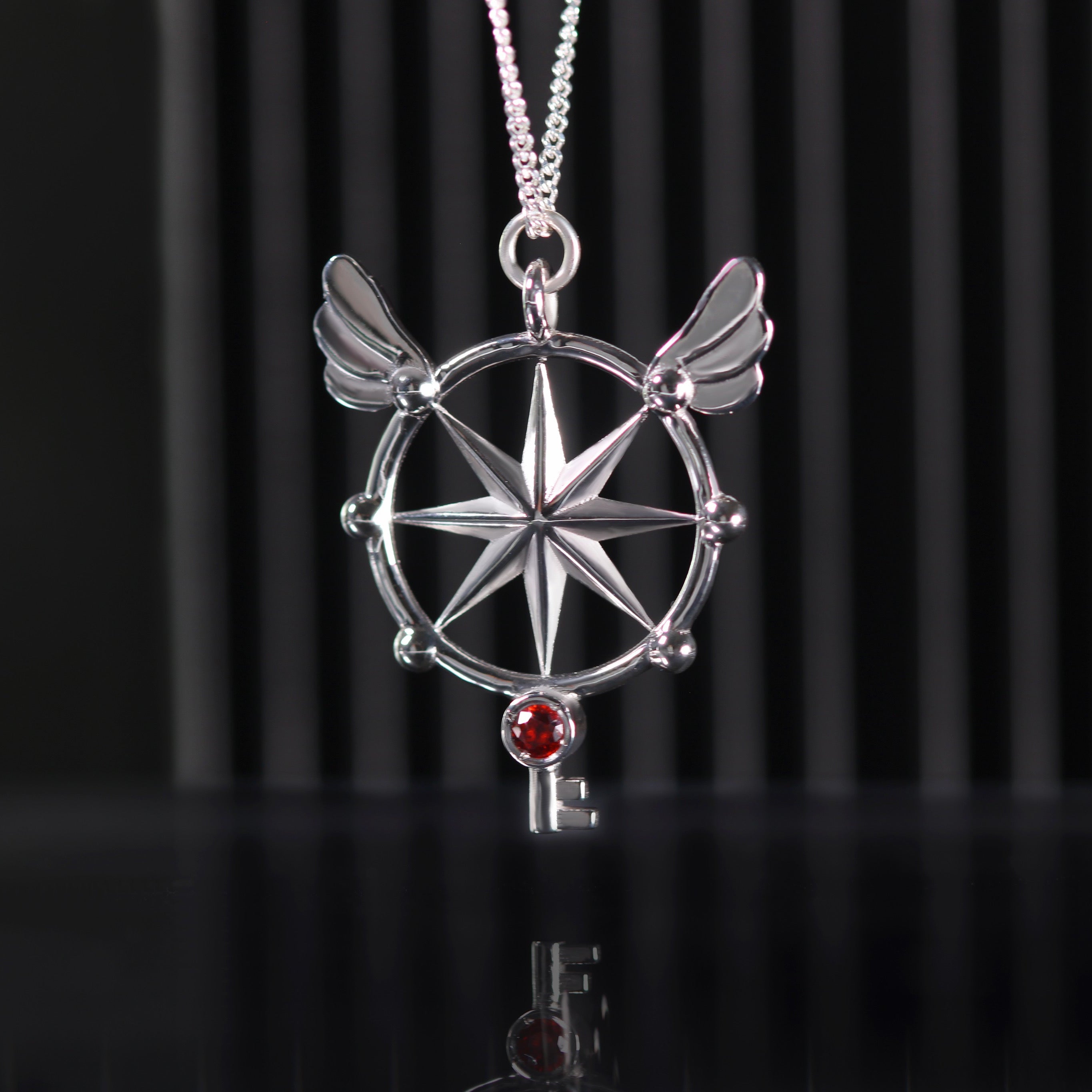 Colgante de llave de cristal en plata de ley con granate rodolita