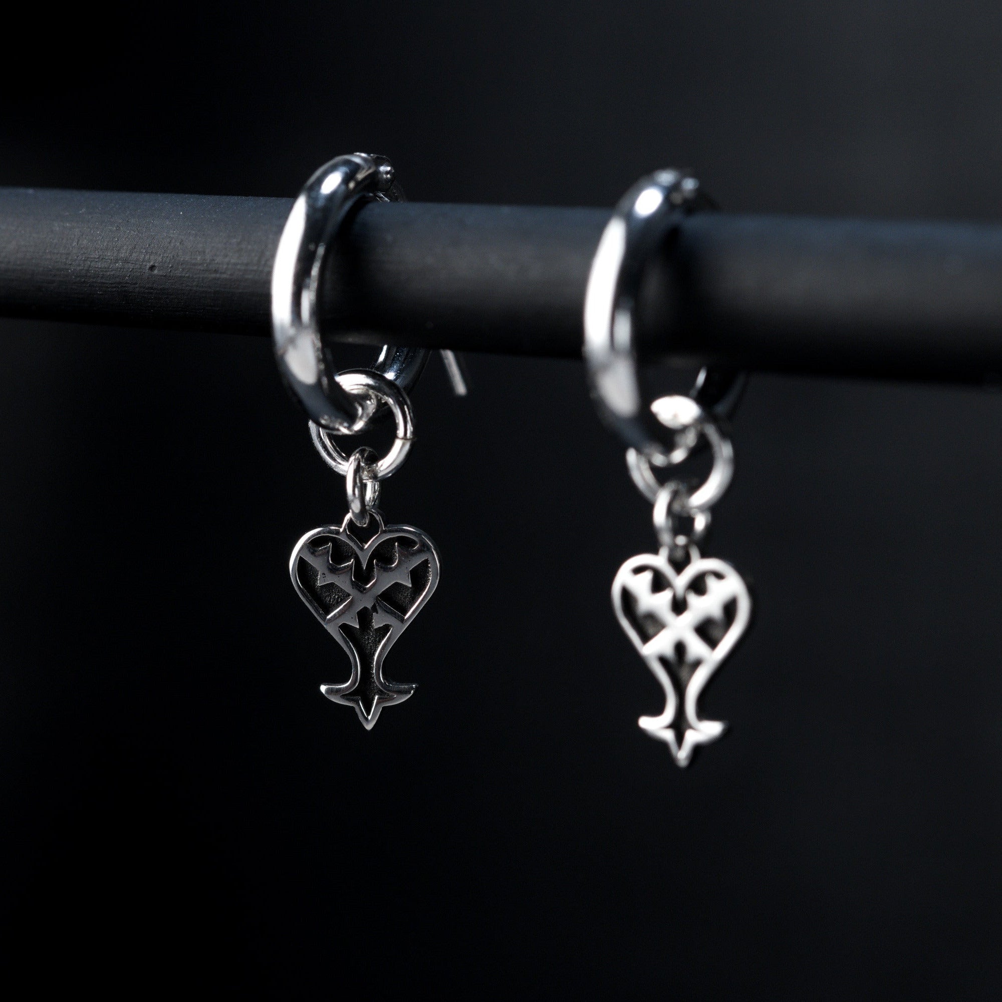Detalle de Kage Earrings de aro mostrando el charm de corazón invertido en plata de ley