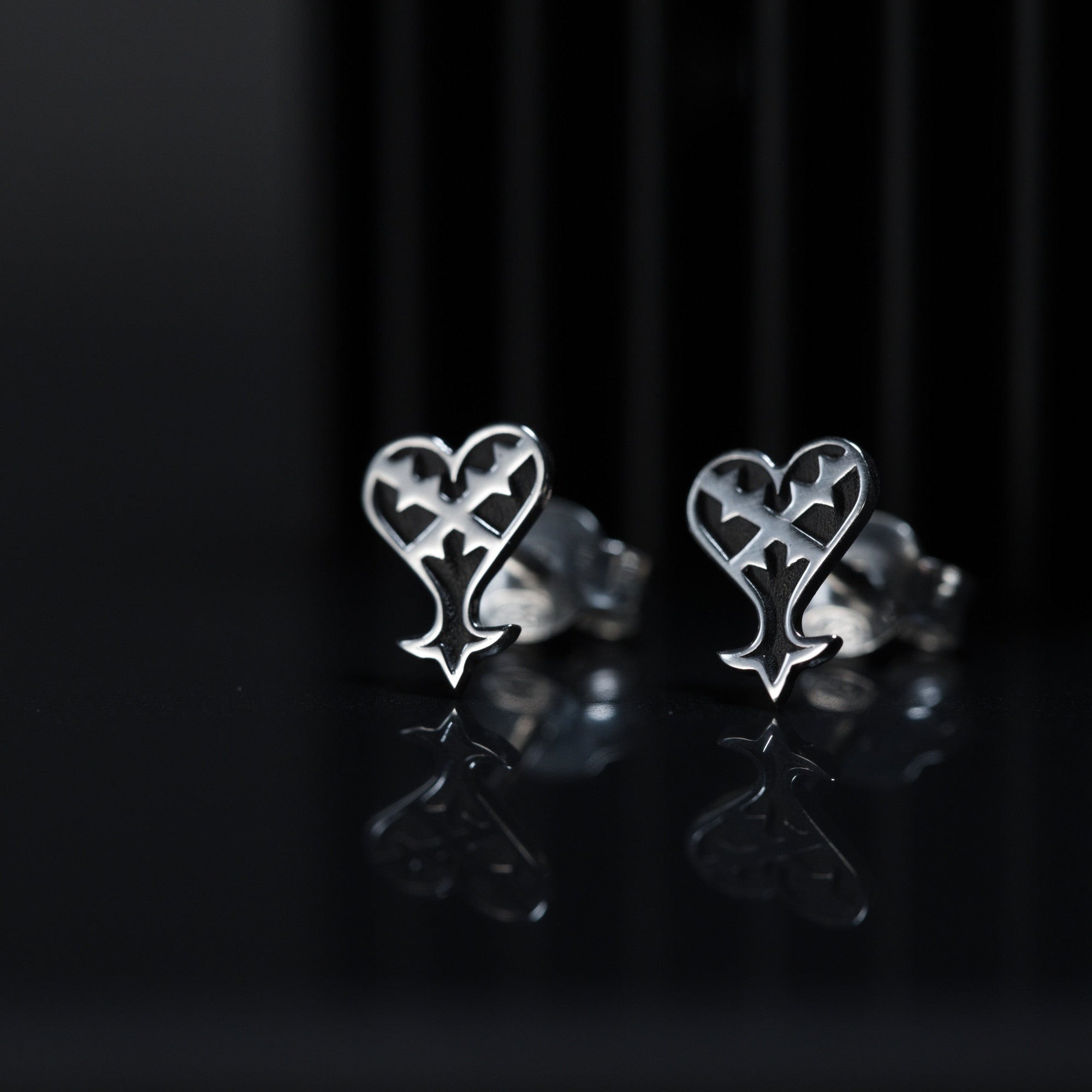 Kage Earrings de presión en plata de ley con símbolo de corazón invertido que representa la oscuridad