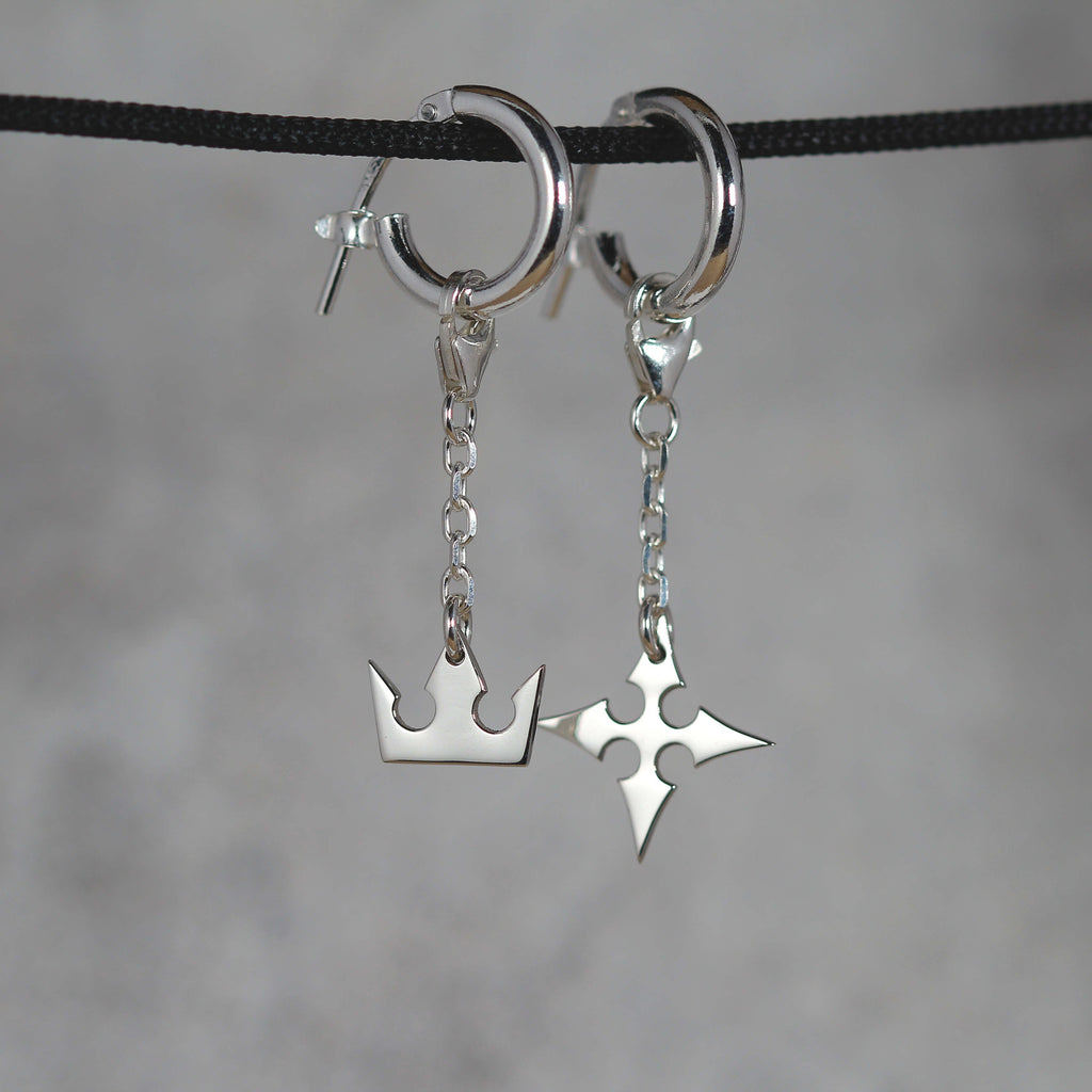 Vista completa de Korona Earrings de cadena en plata de ley con símbolos de corona y cruz y detalle de cadena