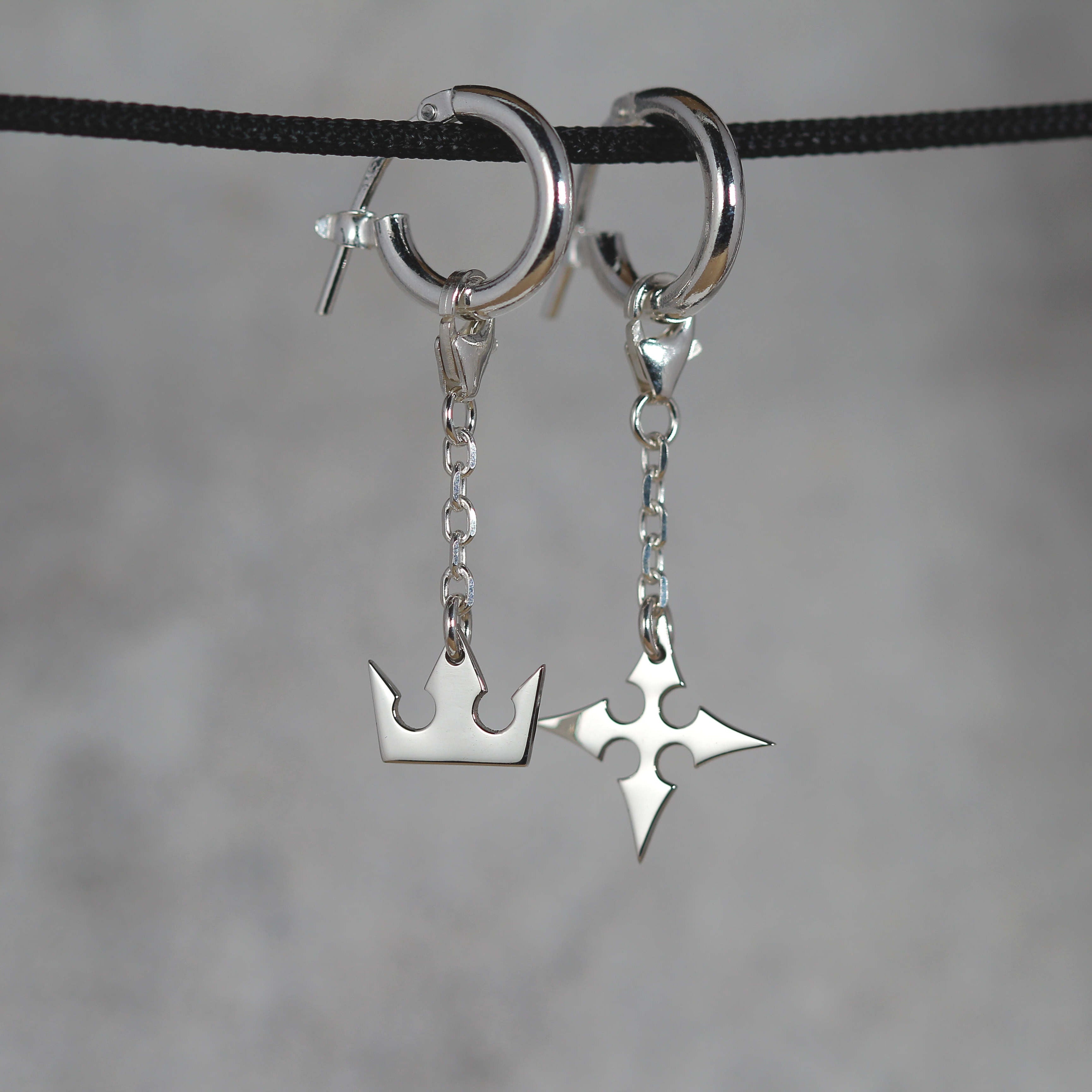 Vista completa de Korona Earrings de cadena en plata de ley con símbolos de corona y cruz y detalle de cadena
