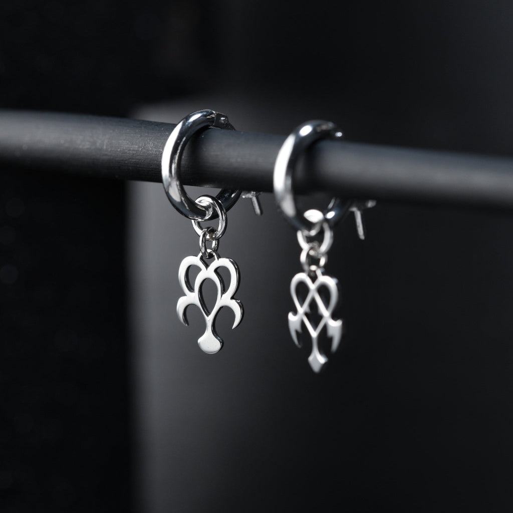 Yume Earrings de aro puestos, mostrando un diseño equilibrado y expresivo de sueño y pesadilla